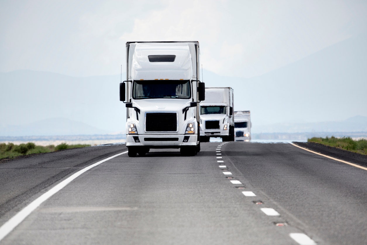 Freight trucks on highway at sunset