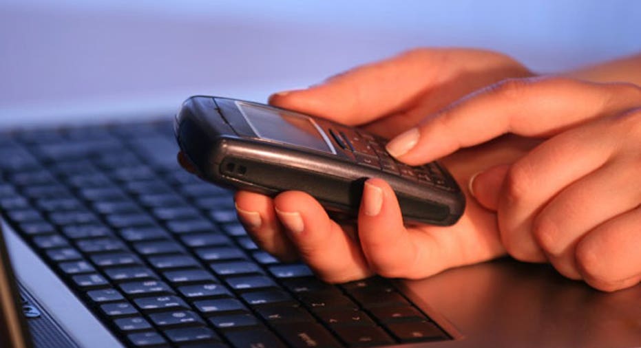 Man Using Cell Phone and Laptop