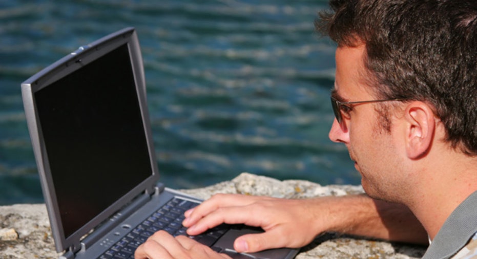 Man Using Laptop Near Beach