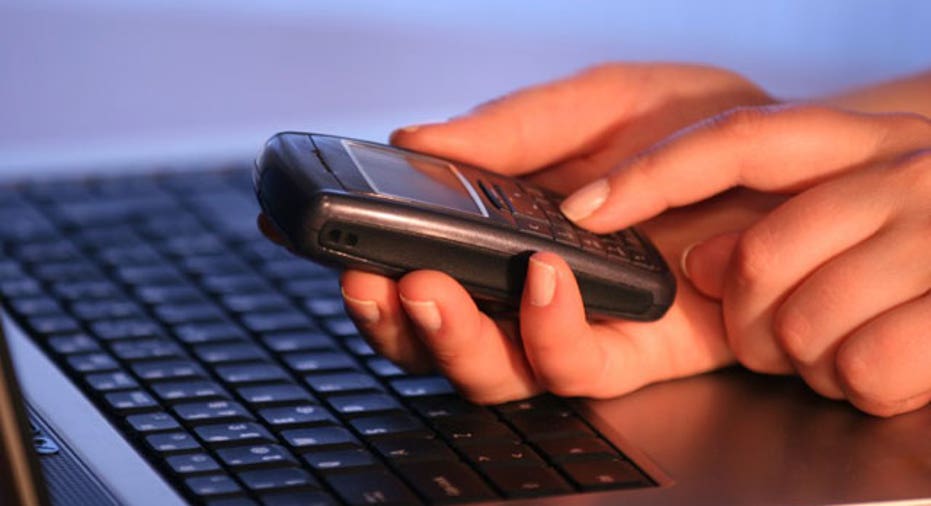 Man Using Cell Phone and Laptop