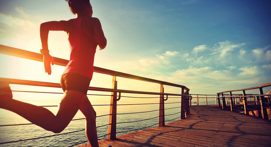 healthy lifestyle sports woman running on wooden boardwalk sunrise seaside