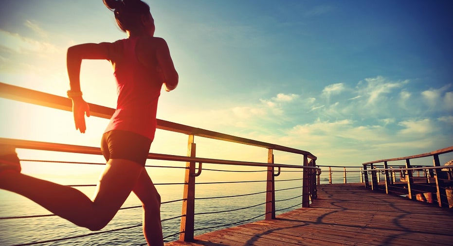 healthy lifestyle sports woman running on wooden boardwalk sunrise seaside