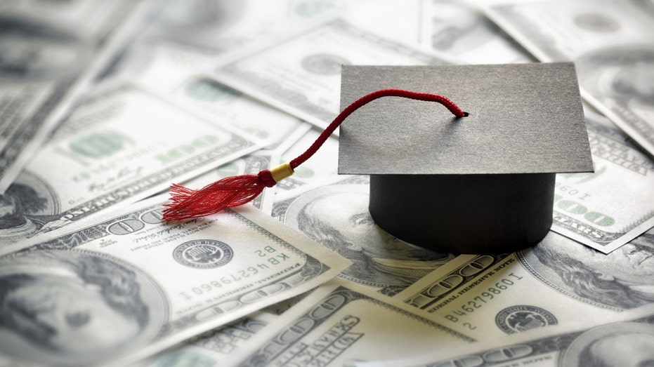 Money pile with graduation cap