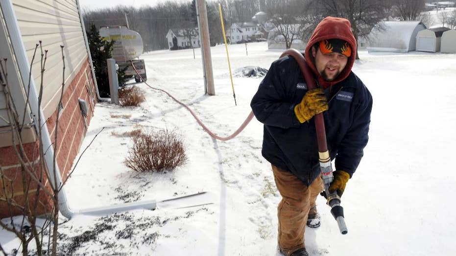 In this Jan. 7, 2014, file photo, Denver Walker, of Somerset Fuels, makes a heating oil delivery to a home in Jenner Crossroads, Pennsylvania.