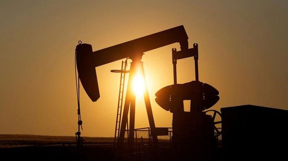 Silhouette of working oil pumps on sunset background