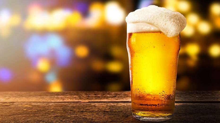 glass of beer on a table in a bar on blurred bokeh background