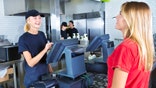 A young woman customer placing her order at a fast food restaurant.