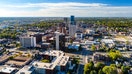 Aerial view of Downtown Lexington, Kentucky with a blue sky with clouds and the metropolitan area cityscape in the background.