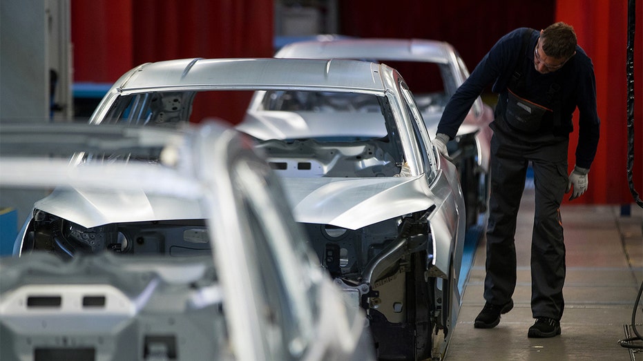 worker inspecting ford