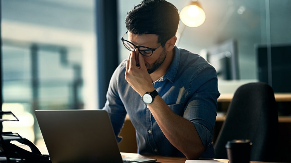 Stressed man pinches nose