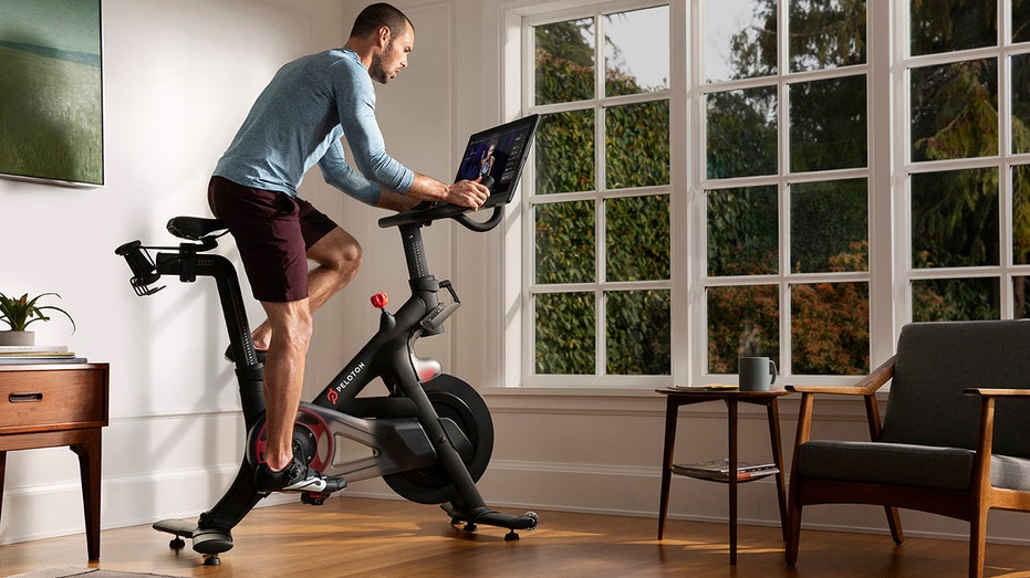 man on Peloton bike in room facing window