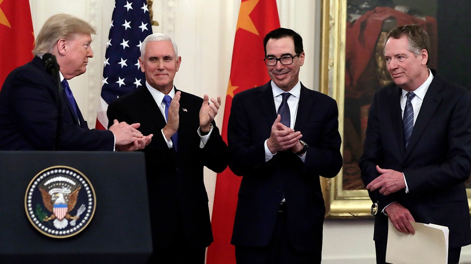 Trump acknowledges Vice President Mike Pence, Treasury Secretary Steven Mnuchin and U.S. Trade Representative Robert Lighthizer. (AP Photo/Evan Vucci)