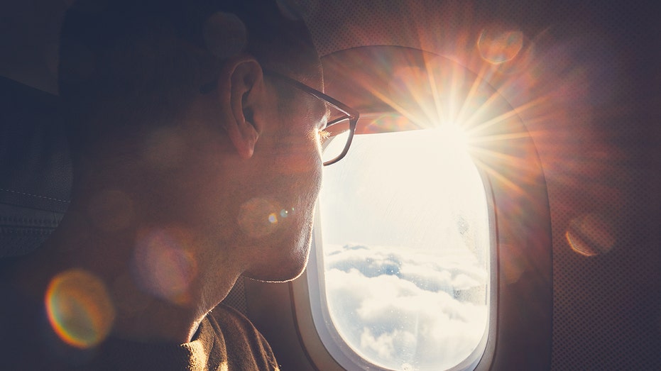 Man looks out airplane window