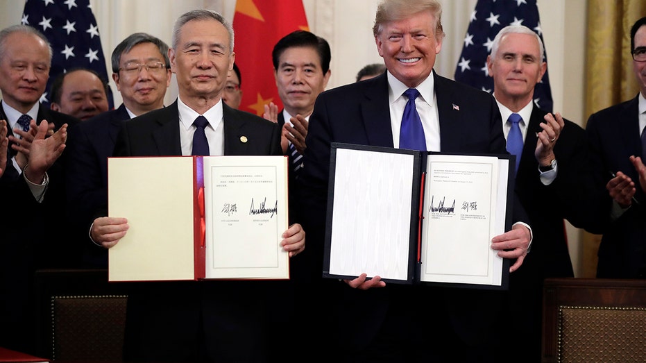 President Trump signs a trade agreement with Chinese Vice Premier Liu He, in the East Room of the White House, Wednesday. (AP Photo/Evan Vucci)