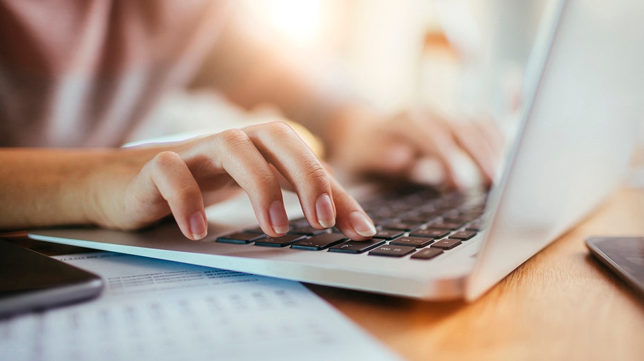 Woman types on laptop