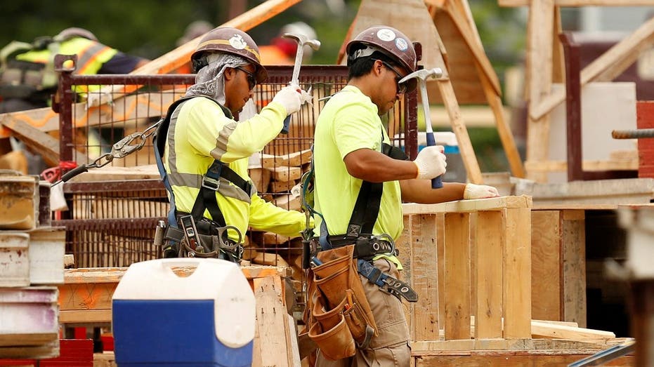 home construction workers use hammers at job site