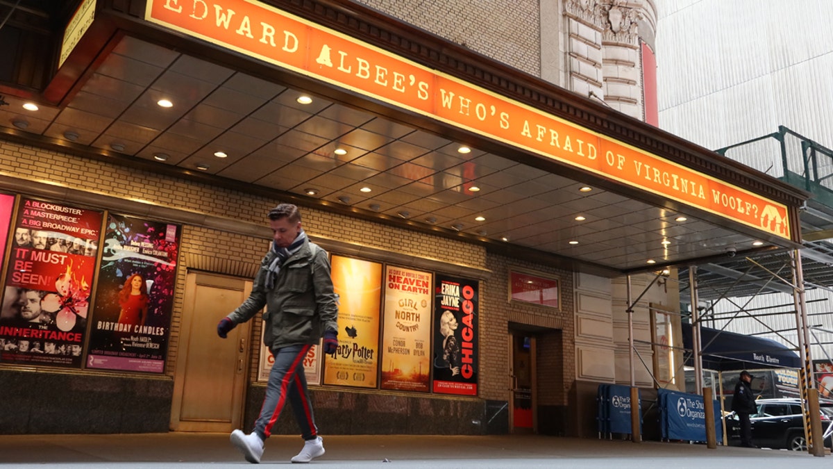 NEW YORK, NY - MARCH 12: A man walks past the Booth Theatre after it was announced Broadway theatres will close for a month on March 12, 2020, in New York City. Closures have recently returned to New York amid a COVID case surge. (Photo by Gary Hershorn/Getty Images)