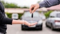 transportation and ownership concept - customer and salesman with car key outside. Woman at a car dealership buying an auto, the sales rep giving her the key, macro shot with focus on hands and key - Fox News
