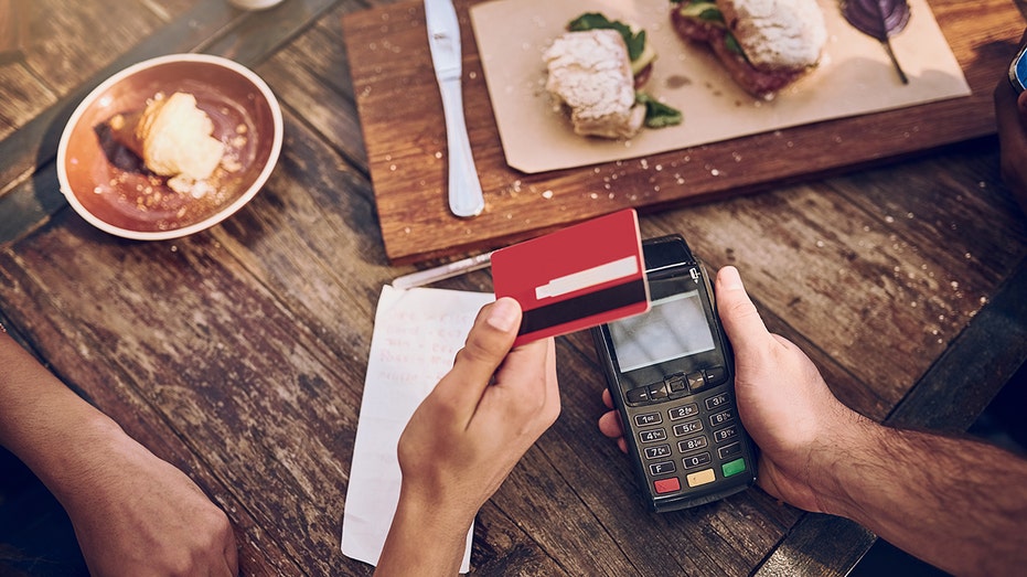 Cropped shot of a man ready to pay the bill at a cafe