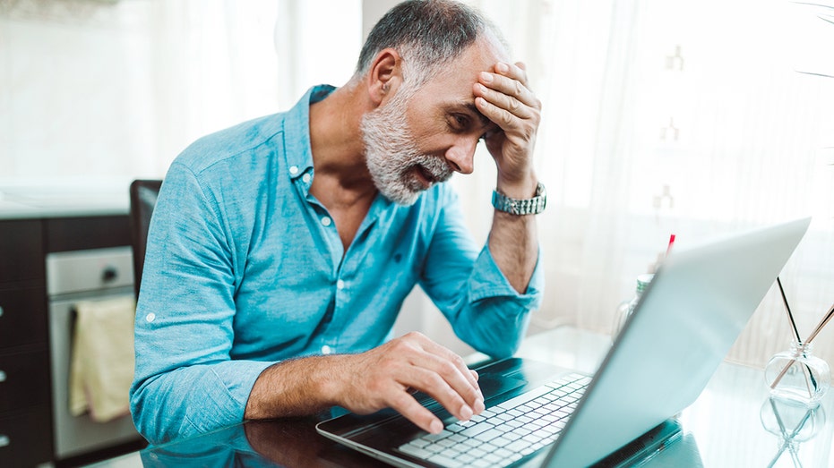 tired and upset man on laptop