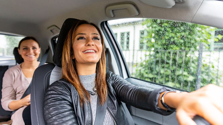 Woman drives car with passenger