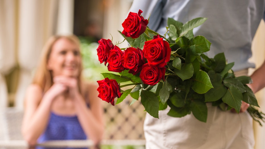Man greeting woman with red roses