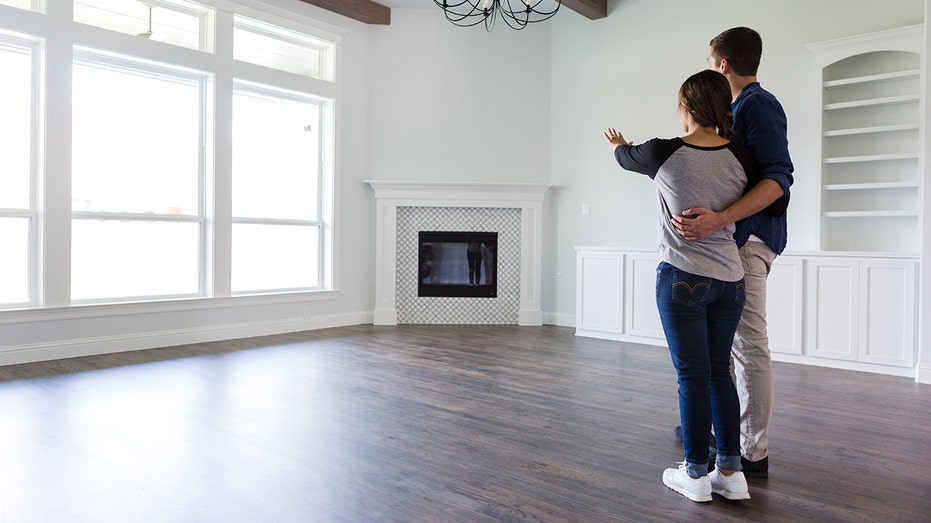 Couple look at the inside of an empty new home.