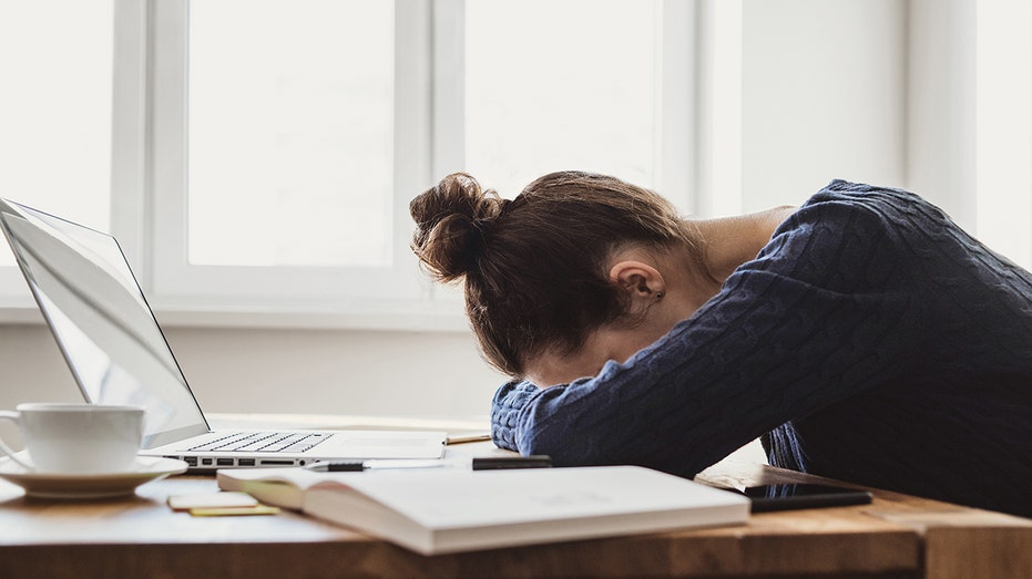 Mujer cansada en su computadora portátil