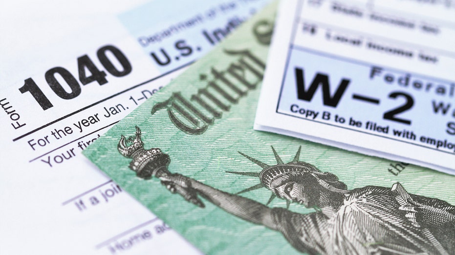 A 1040 income tax form and W-2 wage statement with a federal Treasury refund check. 