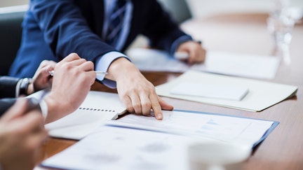 Three businessmen meeting in a conference room.