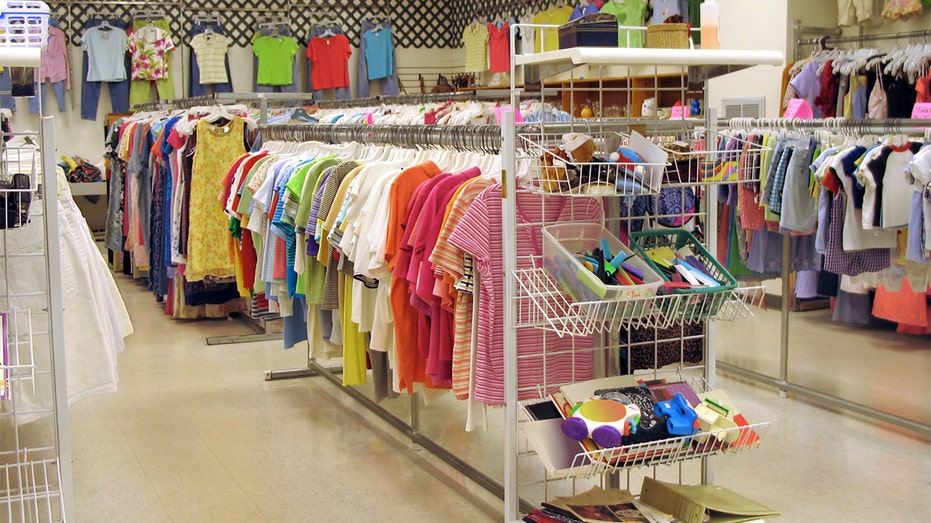 Brightly colored T-shirts hanging on thrift store rack