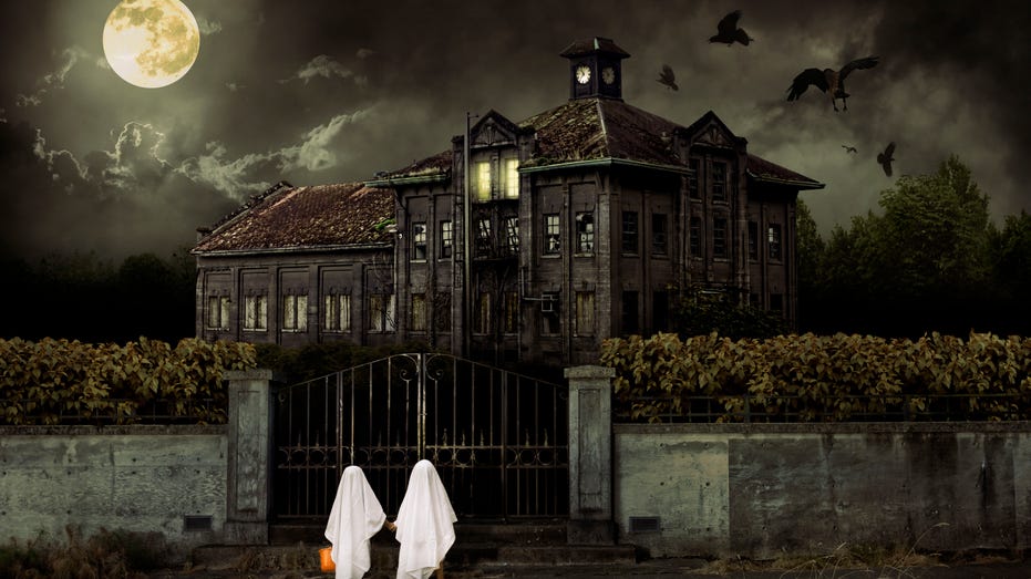 Children in Ghost Costumes Trick or Treat at Haunted House