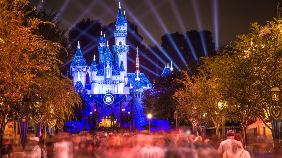 Disneyland 60th aniversary castle with people walking