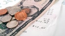 Restaurant bill with dollar bills (tips) on a plate and receipt close up