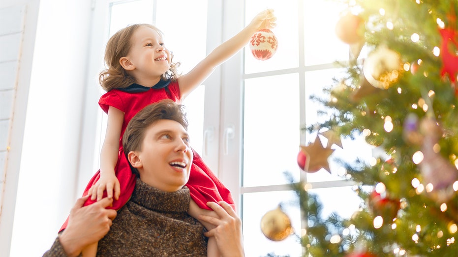 Dad and daughter decorate Christmas tree