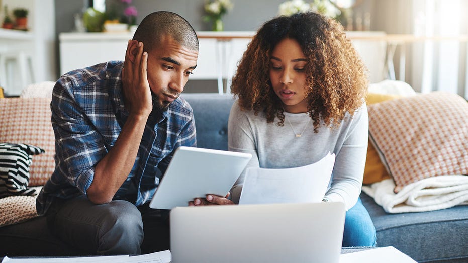 Laptop being used by a couple to review finances.