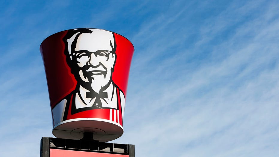 Colonel Sanders' image on bucket-shaped sign above KFC franchise