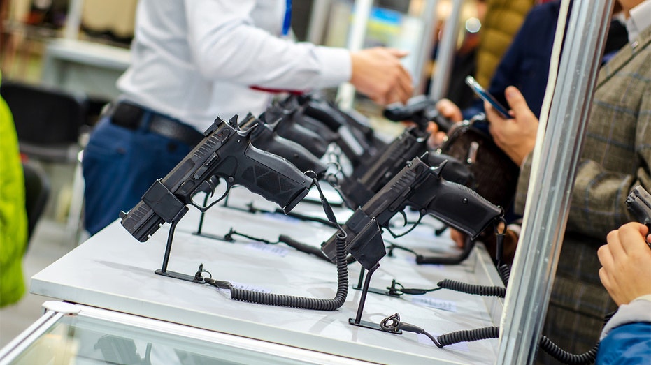 Customers look at guns on display