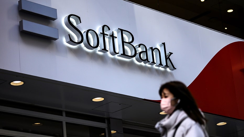 Softbank building with sign, person walks in front of building