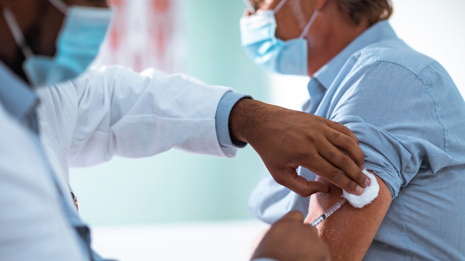 Closeup of man receiving a vaccine shot