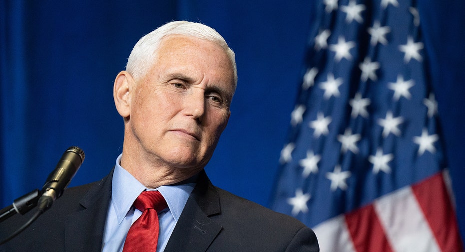 former VP Mike Pence looks on in front of American flag