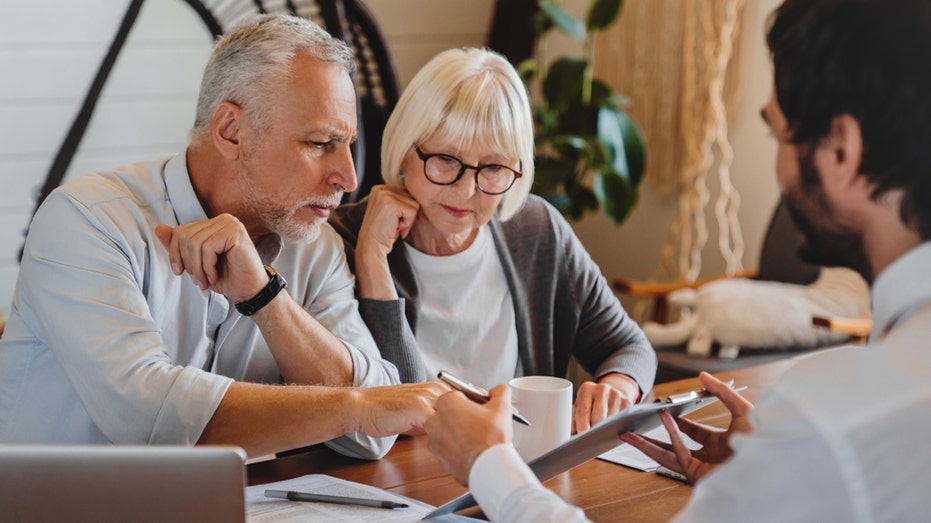 Retiring couple discussing 401k plans with a financial advisor