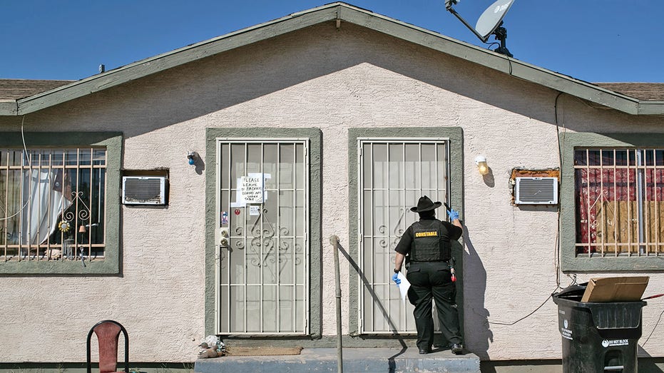 sherriff serves eviction notice at a home