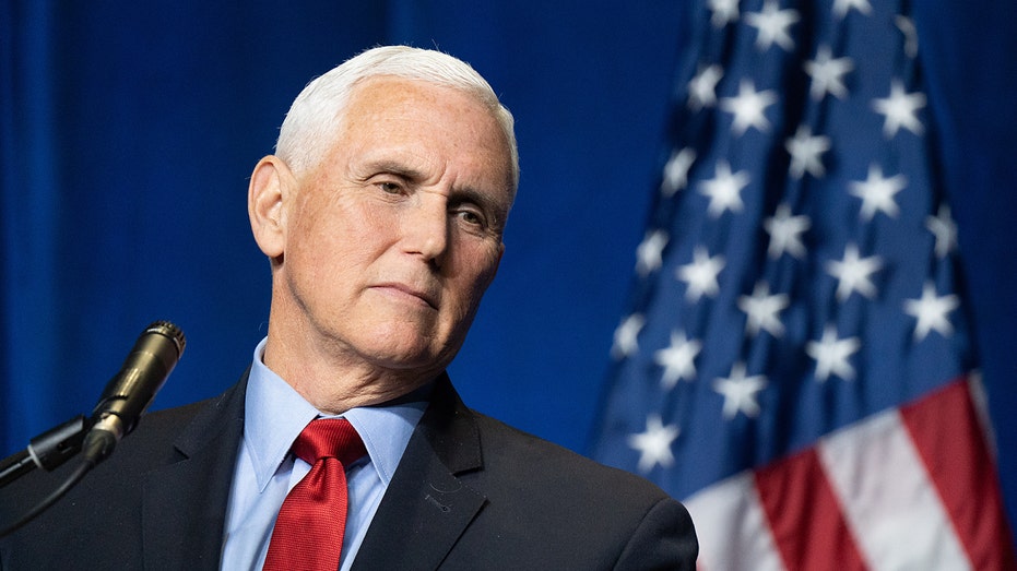 former VP Mike Pence looks on in front of American flag 