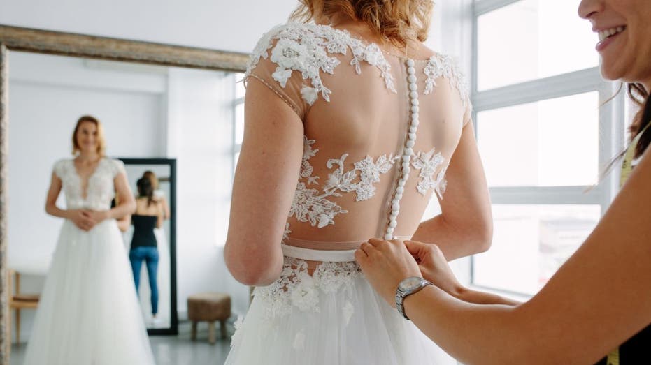 Bride tries on wedding dress.