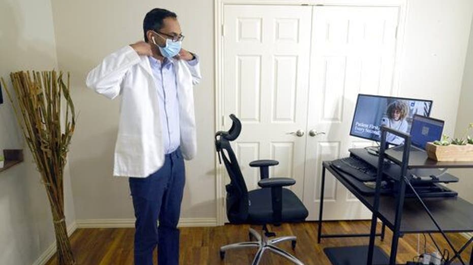 Medical director of Doctor on Demand Dr. Vibin Roy prepares to conduct an online visit with a patient from his work station at home, Friday, April 23, 2021, in Keller, Texas. Some U.S. employers and insurers want you to make telemedicine your first choice for most doctor visits. Retail giant Amazon and several insurers have started or expanded virtual-first care plans to get people thinking telemedicine routinely, even for annual checkups. (AP Photo/LM Otero)