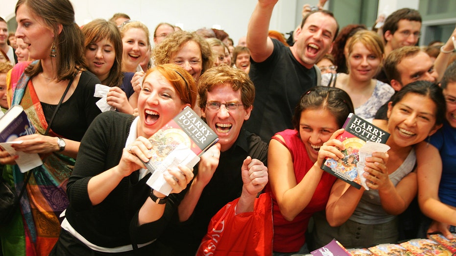 BERLIN - JULY 21: Fans hold the last book by J.K. Rowling "Harry Potter and the Deathly Hallows" in their hands at a bookstore after its release at 1:01am on July 21, 2007 in Berlin, Germany. (Photo by Andreas Rentz/Getty Images)