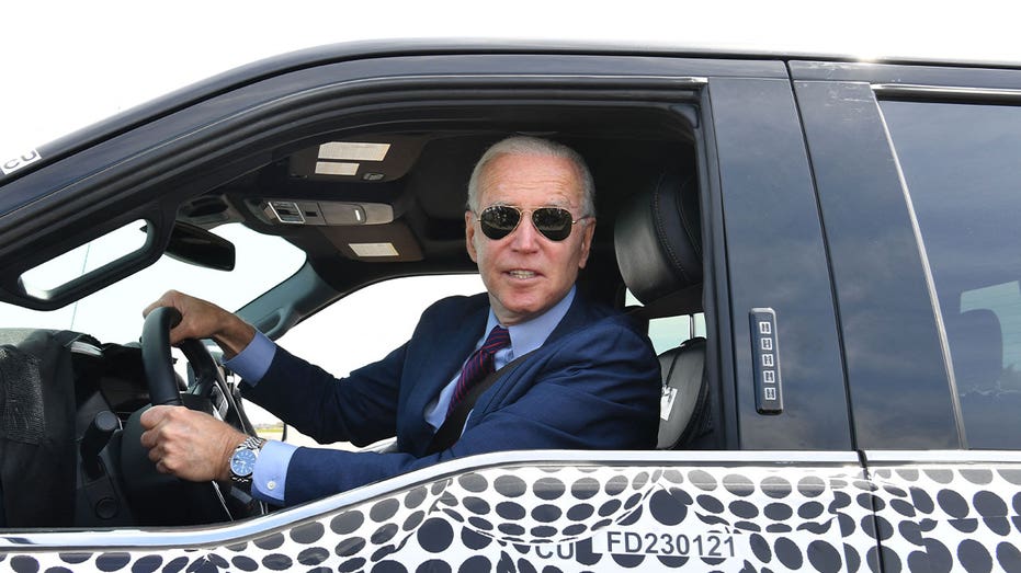 President Joe Biden sits in a Ford electric vehicle during a factory tour.