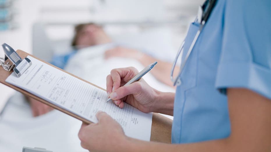 nurse working on patient chart