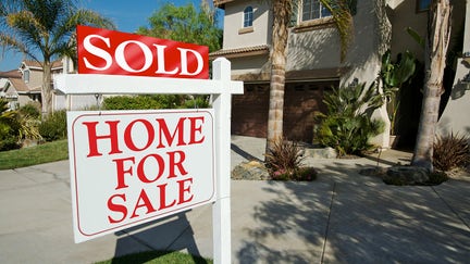 Sold Home For Sale Sign and New House